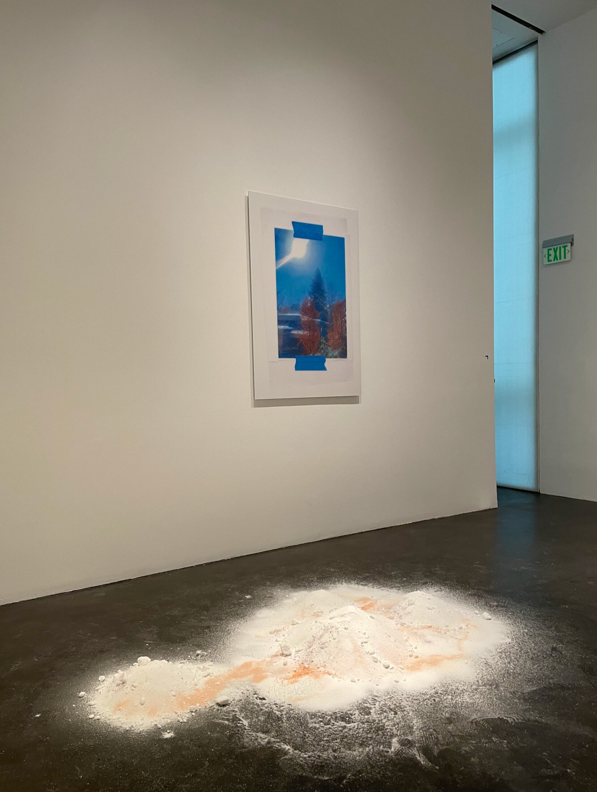 Devon Dikeou's Vision Board, a photograph of an Aspen window view held with blue painters tape, on the wall above Aspen Snow, salt spread across the gallery floor at MCA Denver